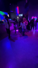 Evening social gathering at purple-lit club in Perm, Russia