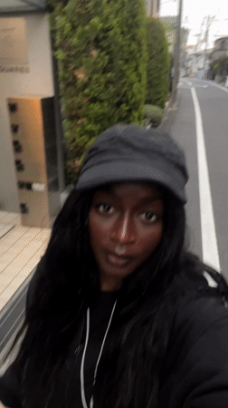 Person walks with phone on Nakano City sidewalk