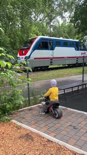 Child watches trains from playground in Ufa, Russia