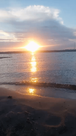 Golden sunset over calm water near Mykolaiv, Ukraine