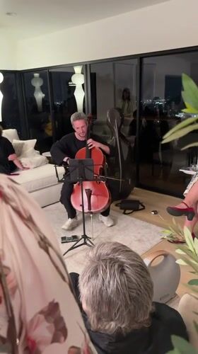 Late-night cello practice in an LA apartment with a city view