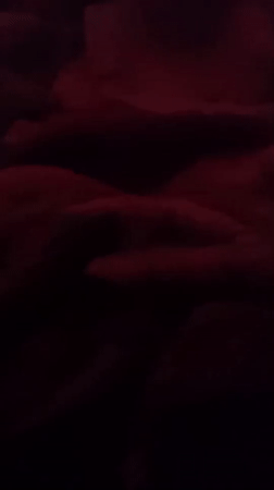 Red-lit room in Jos, hands and blankets in low light