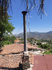 Old chimney on tiled roof, village valley in background, Selçuk