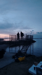 Evening waterfront bonfire gathering in Chaikovsky, Russia draws celebrants