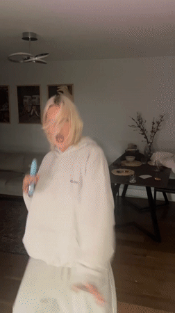 Woman dances and sings with microphone in London apartment