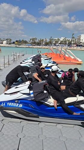 Men in athletic wear gather at sunny Ayia Napa beach resort