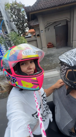 Motorcyclists record street video in Mengwi, Indonesia early morning