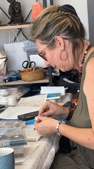 Artisan crafts jewelry at outdoor market in Montbrison
