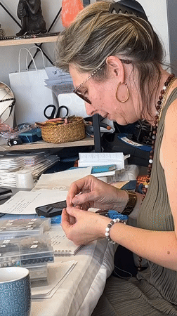 Artisan crafts jewelry at outdoor market in Montbrison