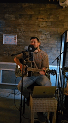 Man in kippah performs acoustic guitar in rustic room