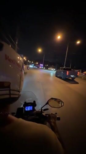 Motorcyclist in RedSuns helmet rides through Kamala, Thailand