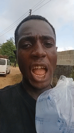 Man poses with household objects in Akwete, Nigeria