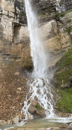 Tall waterfall cascades down rocky cliffs in Kinchkhaperdi, Georgia