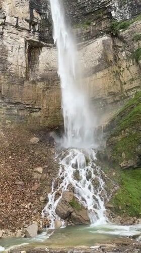 Tall waterfall cascades down rocky cliffs in Kinchkhaperdi, Georgia