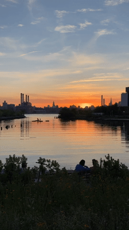 Couple watches sunset at NYC waterfront during golden hour