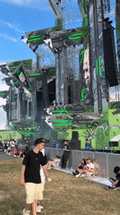 Outdoor music festival stage glows with neon lights and giant screens