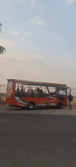 Red open-top bus and mixed traffic on a busy Desa Ngesrep road