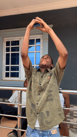 Man photographs companions on couch in sunny Ikorodu scene