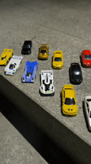 Colorful toy car collection arranged on urban concrete surface