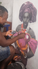 Artist compares colors while working on woman's portrait