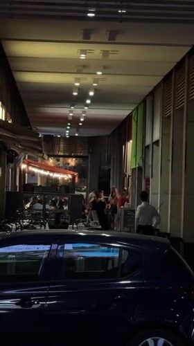 Evening scene under a Milan arcade, dining and socializing