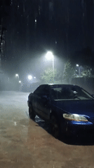 Heavy rain observed in Jos, Nigeria with parked sedan