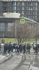Pedestrians cross Moscow street during rainfall with umbrellas