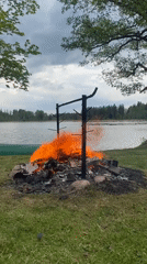 Bonfire burns in stone ring near lake in Latvia