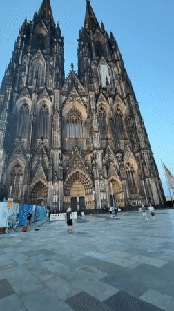 Pan flute busking outside Cologne Cathedral's Gothic spires