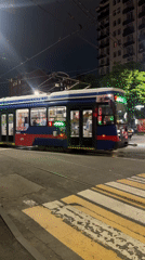 Blue-red-white tram 479 crosses Komgaron intersection at night