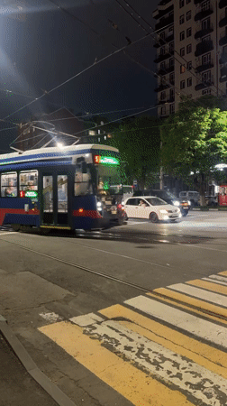 Blue-red-white tram 479 crosses Komgaron intersection at night