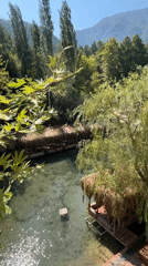 Riverside restaurant with thatched huts over clear water, Alanya