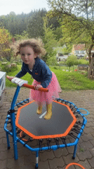 Child plays on backyard trampoline in German village