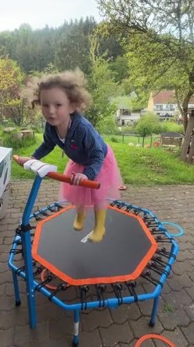 Child plays on backyard trampoline in German village
