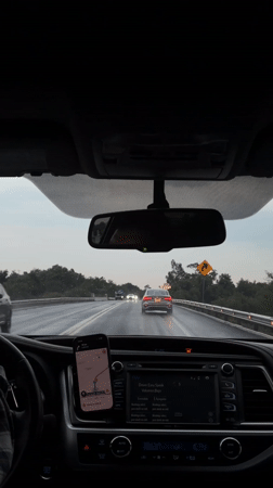 Driver navigates wet highway near Zacatelco using phone GPS