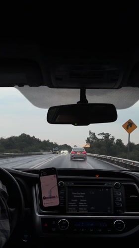 Driver navigates wet highway near Zacatelco using phone GPS