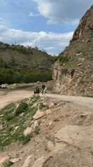 Horsemen and ruins observed in mountainous terrain