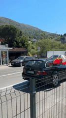 Car displays Montenegro flag while driving through Sutomore