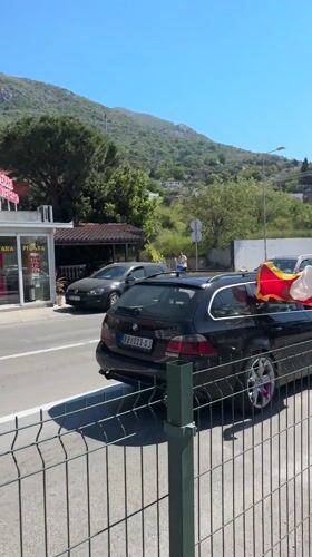 Car displays Montenegro flag while driving through Sutomore