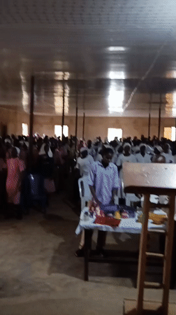 Indoor religious gathering with dancing in white attire