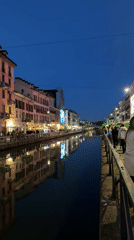 Milan canal district bustling with evening pedestrians at dusk