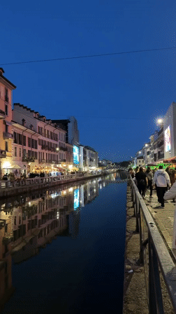 Milan canal district bustling with evening pedestrians at dusk