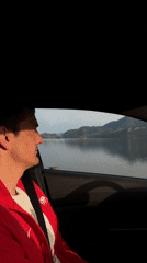 Man observes lakeside scenery from car near Kruševica, Montenegro
