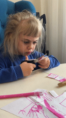 Young child engages in paper cutting craft activity