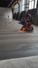 Ride-on trowels finishing a concrete floor in Riga warehouse