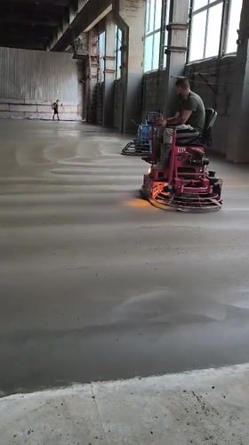 Ride-on trowels finishing a concrete floor in Riga warehouse
