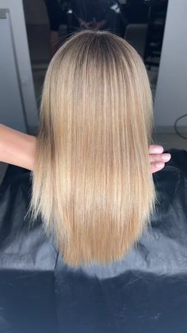 The media file shows a close-up, overhead view of a person's blonde hair. The hair is long, straight, and appears to have been recently styled or treated, as it has a healthy sheen. Two hands, presumably belonging to a hairdresser, are gently holding and arranging the hair, with fingers running through sections of it. The hands and hair are the primary focus, with the background blurred and out of focus.

The setting appears to be a hair salon, suggested by the professional manner in which the hair is being handled and the presence of what looks like a salon cape draped over the person's shoulders. The lighting is bright and even, suggesting an indoor environment, possibly during the daytime. There are no visible text elements in the media file. The overall impression is one of a professional hair styling or treatment session. There are no clear indicators of the time of day or weather conditions. The emotion conveyed is neutral, focusing on the technical aspect of hair care. The context of Timashevsk, Russia, provides a geographical location but does not offer specific visual cues within the media itself.