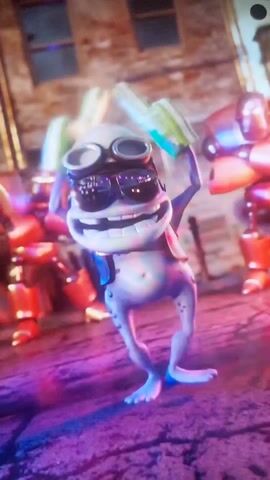 The video shows a 3D animated frog with sunglasses and goggles, holding objects that appear to be rectangular prisms. The frog is wearing a vest and standing in what appears to be a city environment with robots in the background. The lighting is dynamic, with pink and blue hues. The frog moves and changes pose slightly in the video. The sound accompanying the video includes music and vocalizations.
