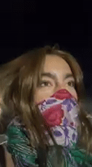 Woman films nighttime selfie wearing floral mask in Indio