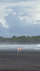 Beachgoers enjoy early morning on Kediri's black sand shore